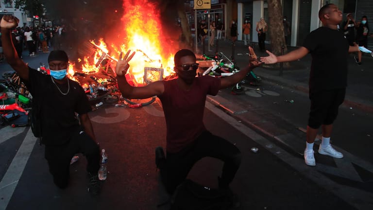 Demonstranten knien vor einer brennenden Barrikade in Paris: Auch in Frankreich starben zuletzt immer wieder Menschen in Polizeigewahrsam.