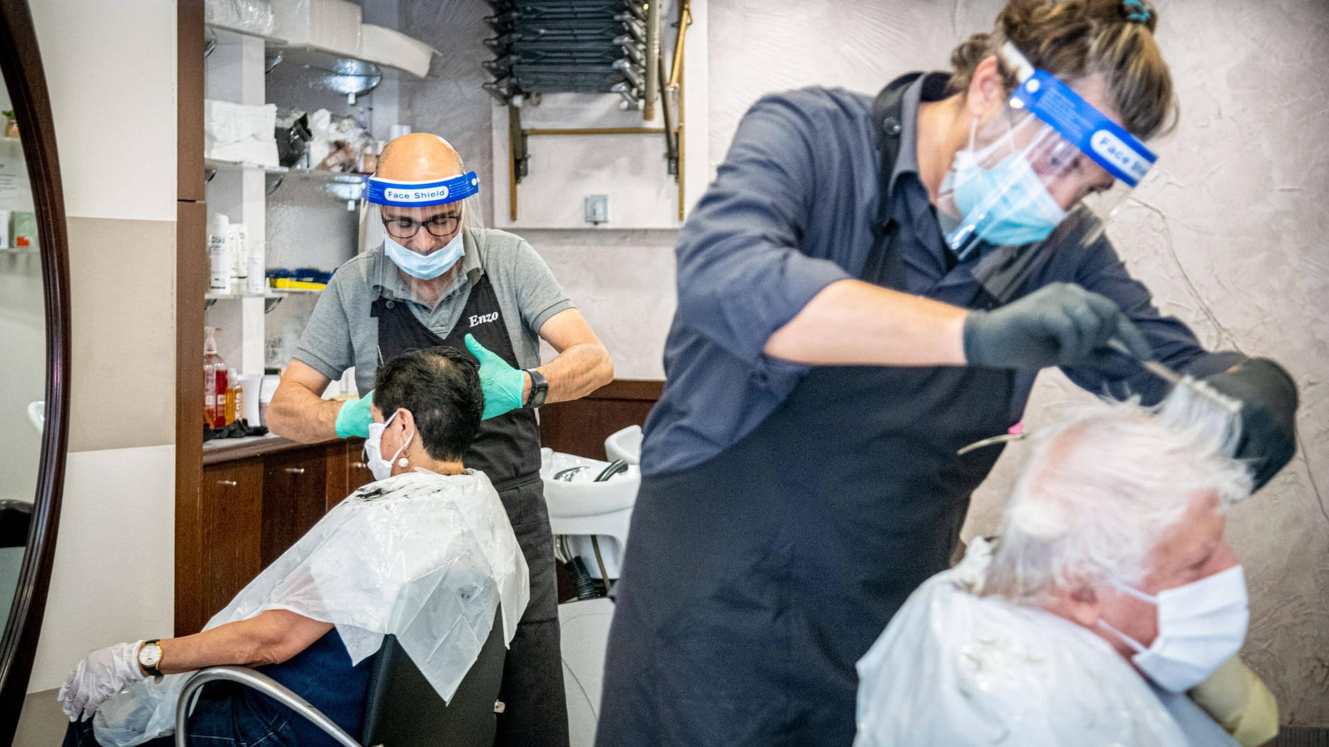 Friseursalon: Berufsgruppen mit engem Menschenkontakt tragen häufig Visiere und Masken.