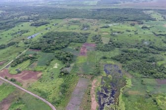 Luftaufnahme von Aguada Fénix mit Dämmen und Stauseen vorne und dem Hauptplateau hinten.