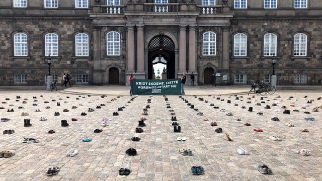 Mit in Reih und Glied aufgestellten Schuhen protestieren dänische Demonstranten vor dem Parlament in Kopenhagen für stärkere Klimaanstrengungen ihrer Regierung. Mit in Reih und Glied aufgestellten Schuhen protestieren dänische Demonstranten vor dem Parlament in Kopenhagen für stärkere Klimaanstrengungen ihrer Regierung.
