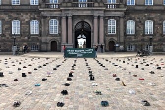 Mit in Reih und Glied aufgestellten Schuhen protestieren dänische Demonstranten vor dem Parlament in Kopenhagen für stärkere Klimaanstrengungen ihrer Regierung.
