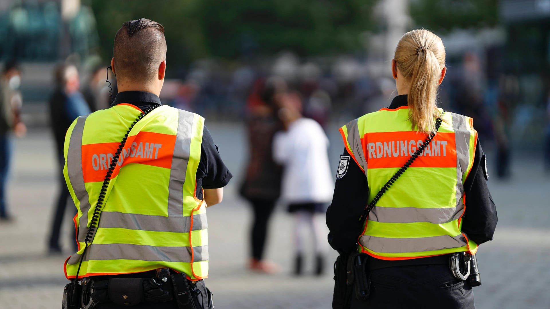 Mitarbeiter des Kölner Ordnungsamtes auf dem Heumarkt: Personen sollen den Mindestabstand einhalten. Mitarbeiter des Kölner Ordnungsamtes auf dem Heumarkt: Personen sollen den Mindestabstand einhalten.