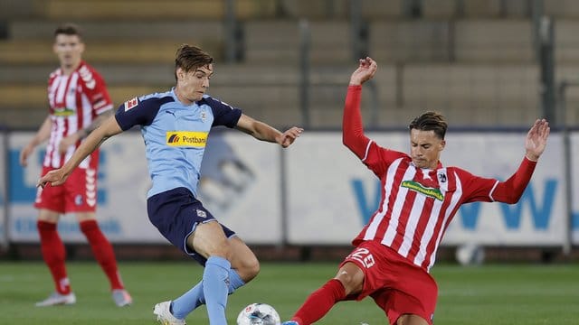 Der Freiburger Robin Koch (r) grätscht gegen Florian Neuhaus. Der Freiburger Robin Koch (r) grätscht gegen Florian Neuhaus.