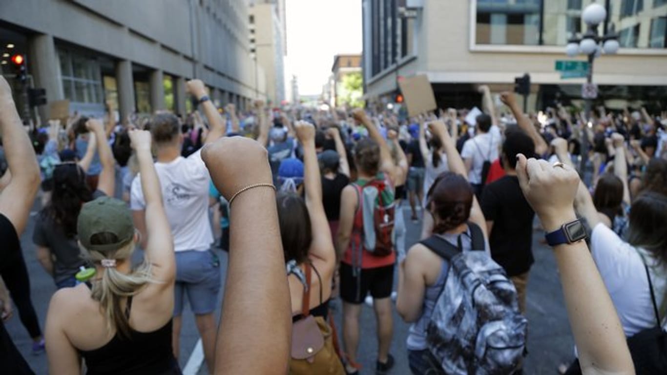 Demonstranten protestieren in der Nähe der Stadt Minneapolis und erheben solidarisch ihre Faust.