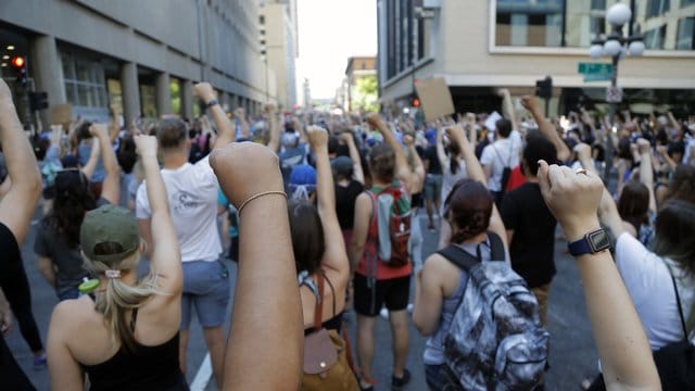 Demonstranten protestieren in der Nähe der Stadt Minneapolis und erheben solidarisch ihre Faust. Demonstranten protestieren in der Nähe der Stadt Minneapolis und erheben solidarisch ihre Faust.