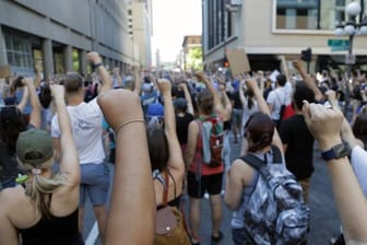 Demonstranten protestieren in der Nähe der Stadt Minneapolis und erheben solidarisch ihre Faust.