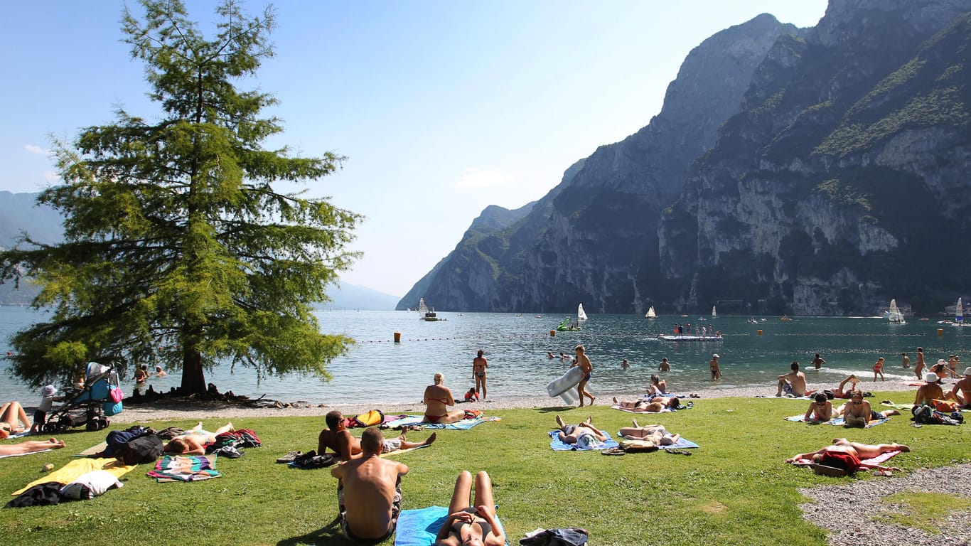 Keine Masken am Strand: Touristen und Einheimische nehmen am Strand von Riva del Garda ein Sonnenbad.
