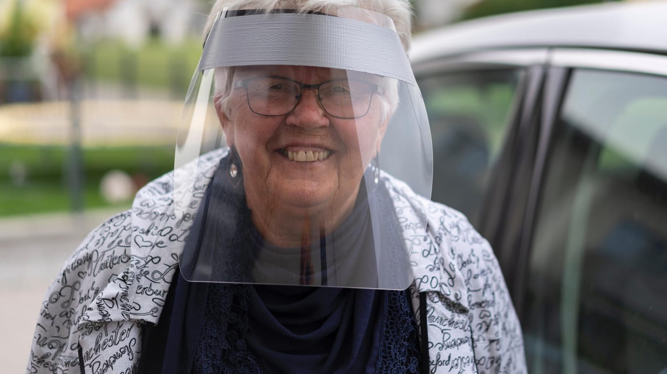 Seniorin mit Visier: Zum Schutz vor SARS-CoV-2 tragen einige Menschen einen Gesichtsschutz aus Plastik.
