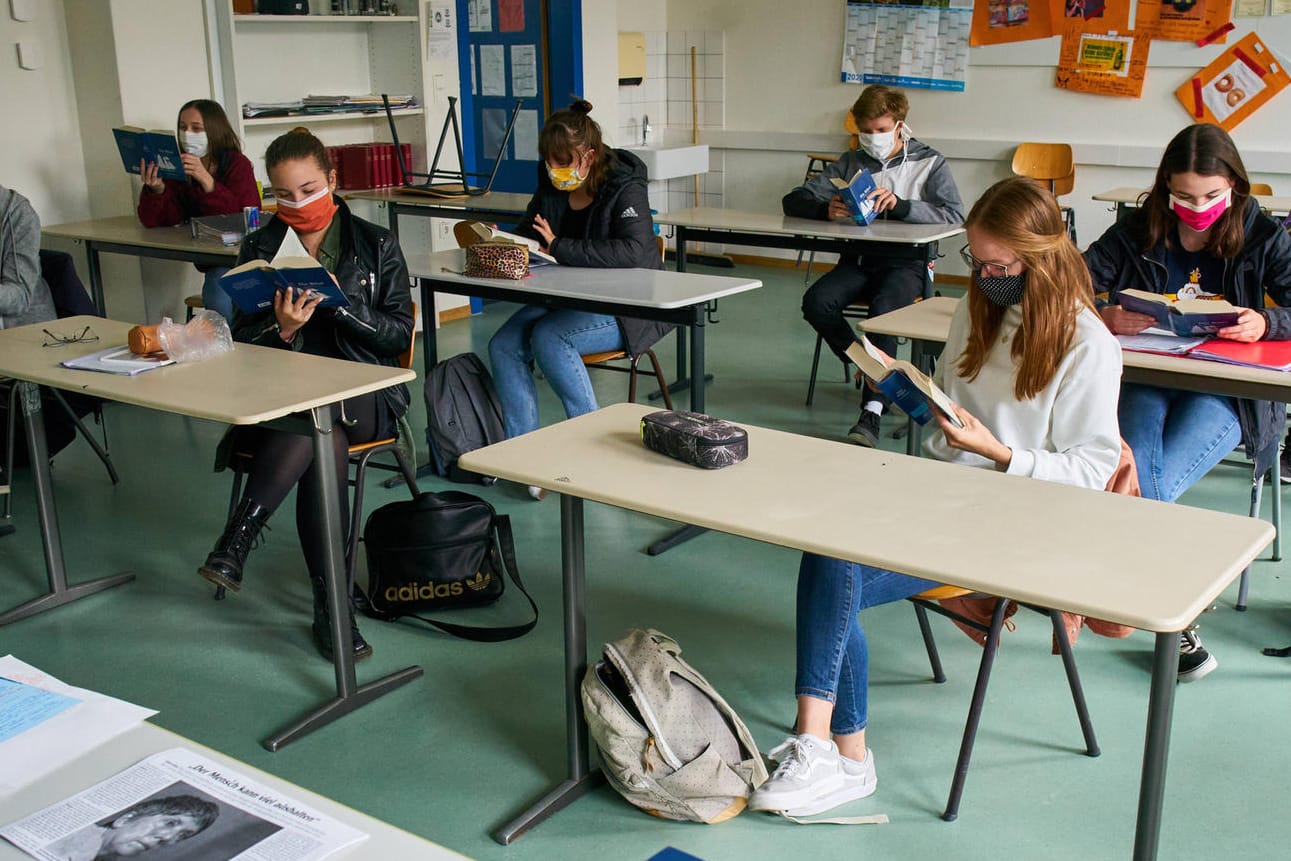 Mit Abstand und Mundschutz sitzen Schüler in einem Klassenraum: Der Deutsche Lehrerverband kann sich den Normalbetrieb in Schulen unter Umständen vorstellen.