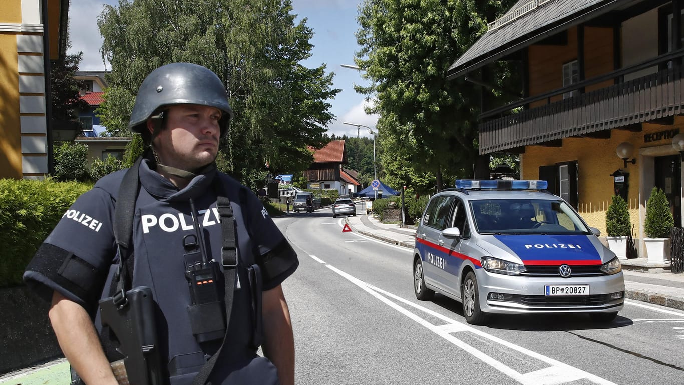 Ein bewaffneter Polizist sichert einen Straßenabschnitt am Tatort einer Tötung. In der Gemeinde Villach ist eine Frau auf offener Straße erschossen worden.
