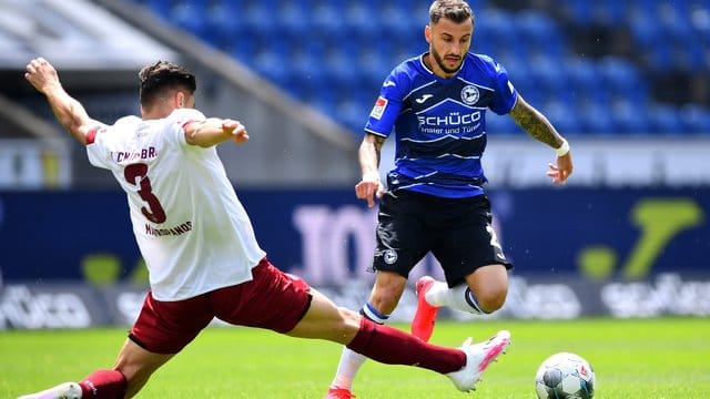 Der Nürnberger Konstantinos Mavropanos (l) grätscht in den Lauf von Arminia-Spieler Jonathan Clauss. Der Nürnberger Konstantinos Mavropanos (l) grätscht in den Lauf von Arminia-Spieler Jonathan Clauss.