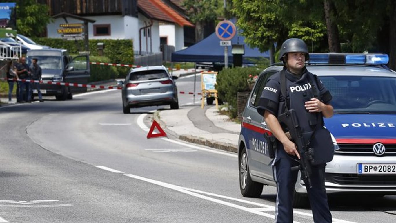 Ein bewaffneter Polizist sichert einen Straßenabschnitt am Tatort einer Tötung in der Gemeinde Villach.
