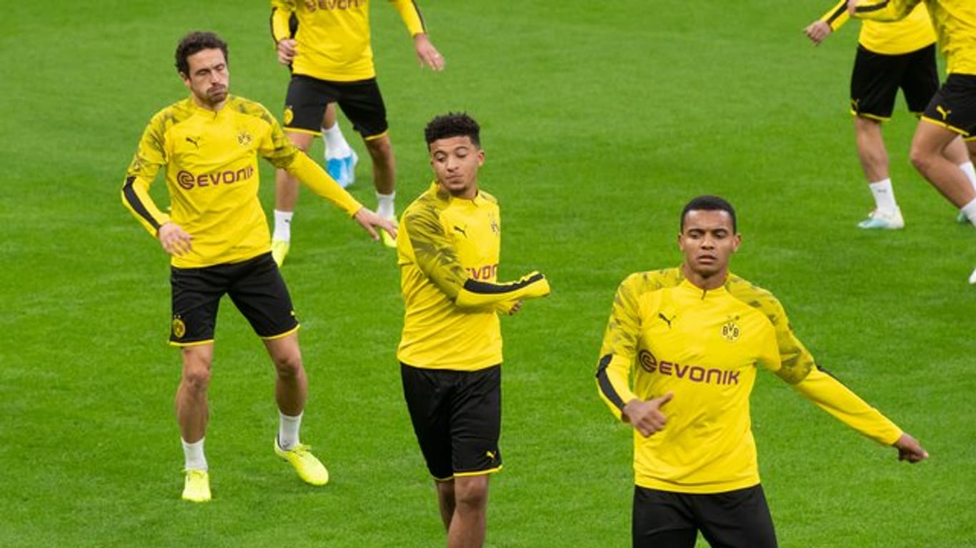 Jadon Sancho (l) und Manuel Akanji stehen trotz der jüngsten Friseur-Affäre in der Startelf von Borussia Dortmund.