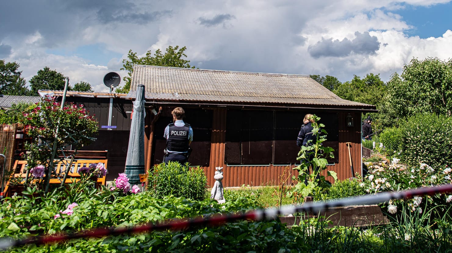 Bei den Ermittlungen nach schwerem sexuellem Missbrauch von Kindern stehen zwei Polizeibeamte an der Rückseite der Gartenlaube.