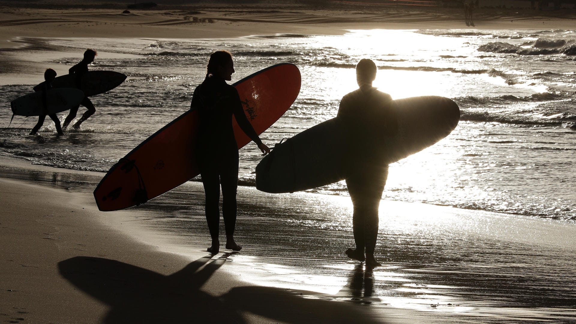 Surfer gehen an einem Strand von Sydney spazieren (Symbolfoto): Vor der Ostküste Australiens hat ein Hai einen Surfer am Sonntag angegriffen und getötet. Surfer gehen an einem Strand von Sydney spazieren (Symbolfoto): Vor der Ostküste Australiens hat ein Hai einen Surfer am Sonntag angegriffen und getötet.