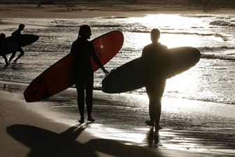Surfer gehen an einem Strand von Sydney spazieren (Symbolfoto): Vor der Ostküste Australiens hat ein Hai einen Surfer am Sonntag angegriffen und getötet.
