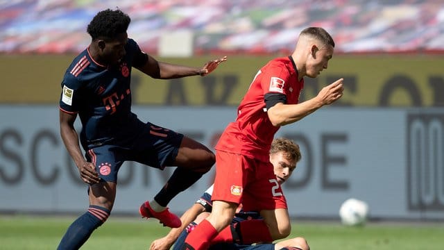 Leverkusens Florian Wirtz (r) setzt sich gegen Alphonso Davies vom FC Bayern durch. Leverkusens Florian Wirtz (r) setzt sich gegen Alphonso Davies vom FC Bayern durch.
