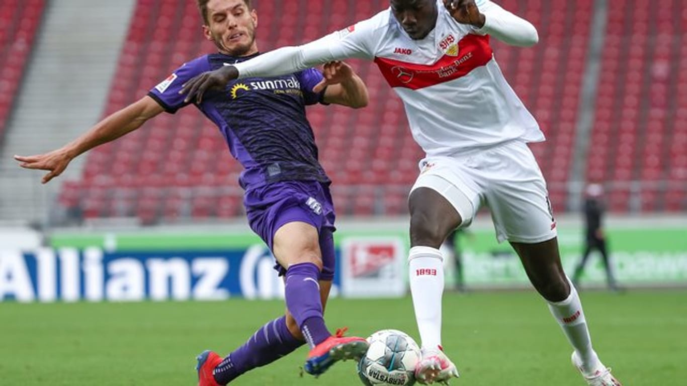 Osnabrücks Bashkim Ajdini in Aktion gegen Tanguy Coulibaly (r) vom VfB Stuttgart.