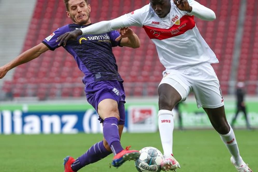 Osnabrücks Bashkim Ajdini in Aktion gegen Tanguy Coulibaly (r) vom VfB Stuttgart.