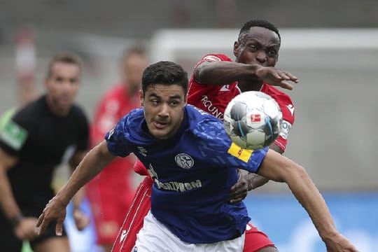 Schalkes Ozan Kabak im Duell mit Unions Anthony Ujah (r).