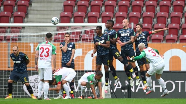 FC Augsburgs Philipp Max schießt den Freistoß über die Mauer aufs Tor.