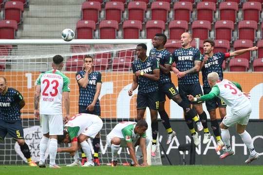 FC Augsburgs Philipp Max schießt den Freistoß über die Mauer aufs Tor.