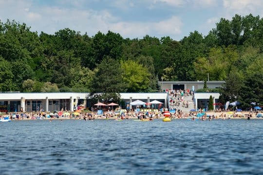 Zahlreiche Menschen bevölkern einen Badestrand: Das Strandbad Müggelsee ist ein beliebtes Erholungsgebiet.