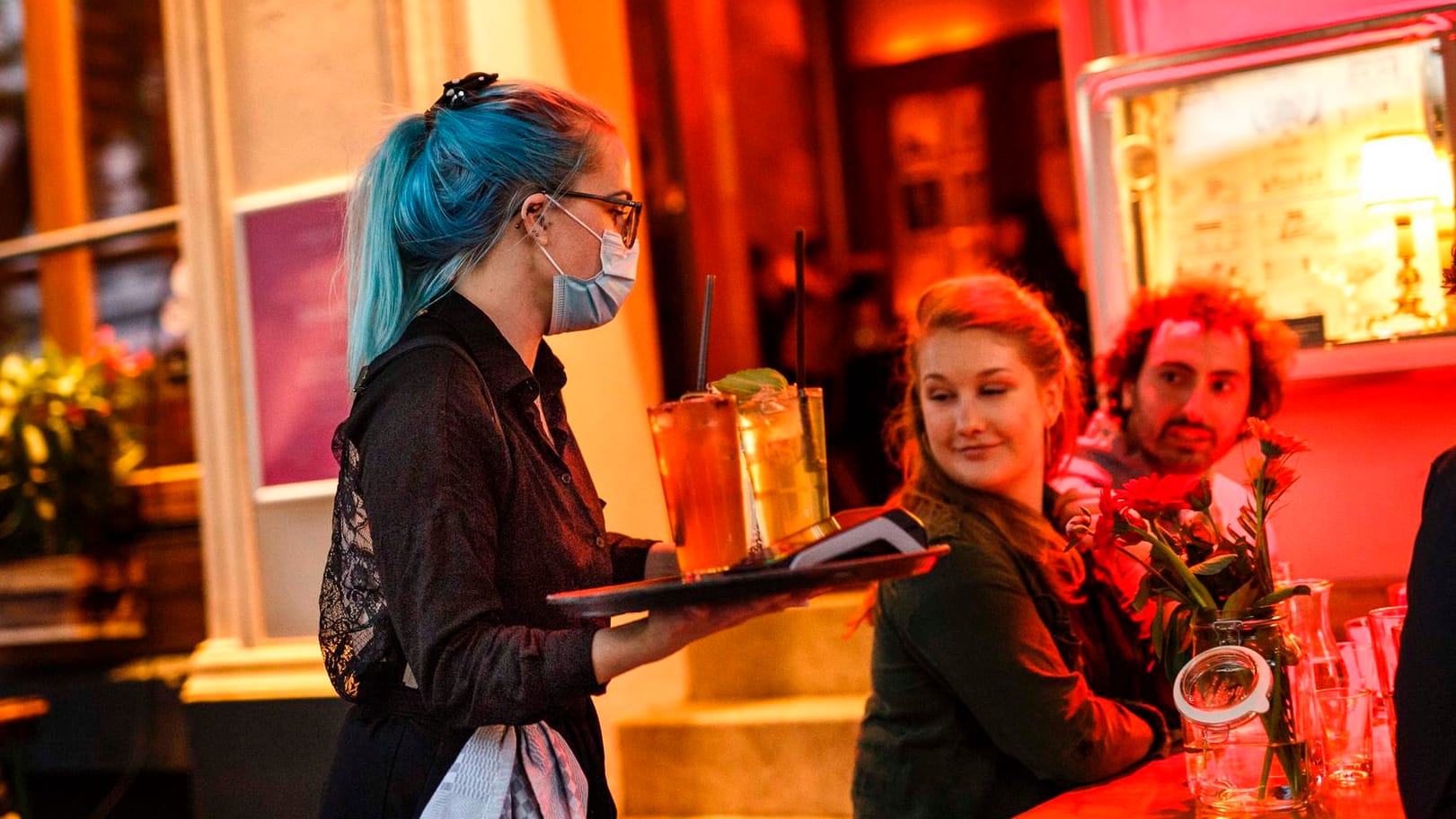 Eine Kellnerin serviert Cocktails an einem Tisch vor der Cocktailbar "Limonadier": In Berlin sollen Lokale länger als nur bis 23 Uhr öffnen dürfen. Eine Kellnerin serviert Cocktails an einem Tisch vor der Cocktailbar "Limonadier": In Berlin sollen Lokale länger als nur bis 23 Uhr öffnen dürfen.