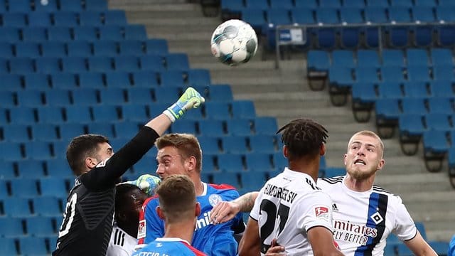 Der Kieler Torwart Ioannis Gelios (l-r) faustet den Ball vor seinen Teamkameraden Phil Neumann, Hauke Wahl und den Hamburgern Josha Vagnoman und Rick van Drongelen weg.