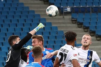 Der Kieler Torwart Ioannis Gelios (l-r) faustet den Ball vor seinen Teamkameraden Phil Neumann, Hauke Wahl und den Hamburgern Josha Vagnoman und Rick van Drongelen weg.