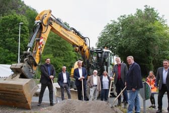 Oberbürgermeister Erik O. Schulz (Mitte, mit Spate) und andere an der Baustelle beteiligte setzen den Spatenstich: In der Volmetalstraße soll ein Kreisverkehr entstehen.