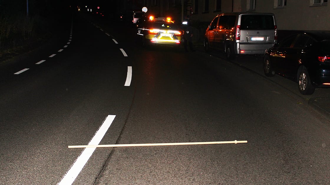 Eine Gardinenstange liegt auf der Straße: Sie soll von zwei Männern mutwillig dort abgelegt worden sein.