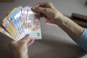 Eine Seniorin hält Bargeld in den Händen (Symbolbild): Zum Juli werden die Renten in Deutschland angepasst.