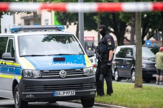Polizist mit Maschinenpistole in der Nähe des Tatorts in München: Drei Personen mussten nach der Attacke ins Krankenhaus.