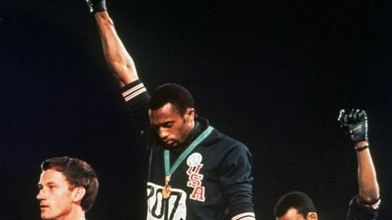Die US-Athleten Tommie Smith (M) und John Carlos (r) streckten während Olympia 1968 die Fäuste, um gegen Rassismus zu protestieren.