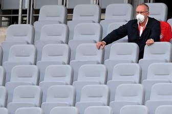 Karl-Heinz Rummenigge (l), Vorstandschef der FC Bayern München AG, sitzt auf der leeren Tribüne.