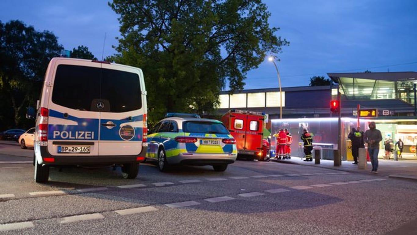 Polizeifahrzeuge und ein Rettungswagen stehen nahe dem Tatort am S-Bahnhof Elbgaustraße: Hier wurden zwei Menschen durch eine Schreckschusspistole verletzt.