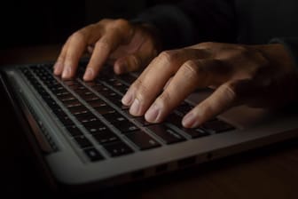 Ein Mann an einem Computer (Symbolbild): Polizei und Tech-Konzerne wollen stärker gegen Kinderpornografie vorgehen.
