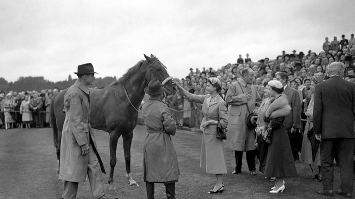 Königin Elizabeth streichelt ihr Pferd Aureole, nachdem es beim Galoprennen in Ascot gewonnen hat.
