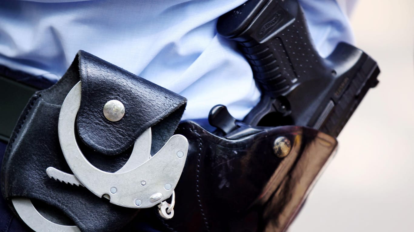 Polizist mit Handschellen und Dienstwaffe am Gürtel: In Brandenburg wurde gegen zwei Beamte Strafanzeige gestellt und ein Disziplinarverfahren eingeleitet. (Symbolbild)