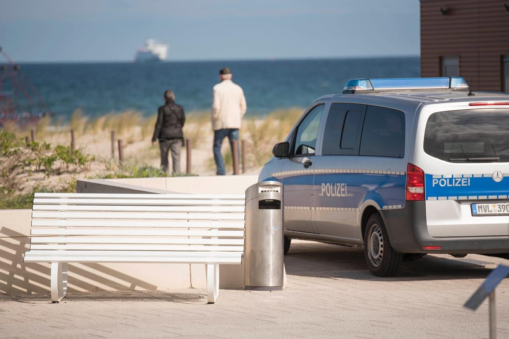 Ein Fahrzeug der Polizei Rostock steht am Strand in Warnemünde: Nach dem Sturz der 103-Jährigen wird wegen der unklaren Umstände ermittelt.