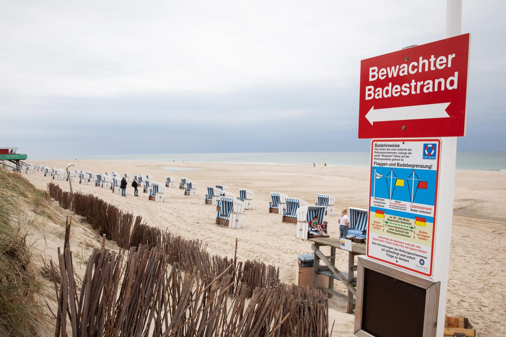 Urlaub: Ein Hinweisschild "Bewachter Badestrand" steht am Zugang zum Strandabschnitt bei Kampen auf Sylt.