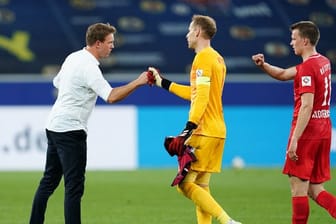 Leipzigs Trainer Julian Nagelsmann (l) klatscht sich nach dem Sieg mit Torwart Peter Gulacsi (M.