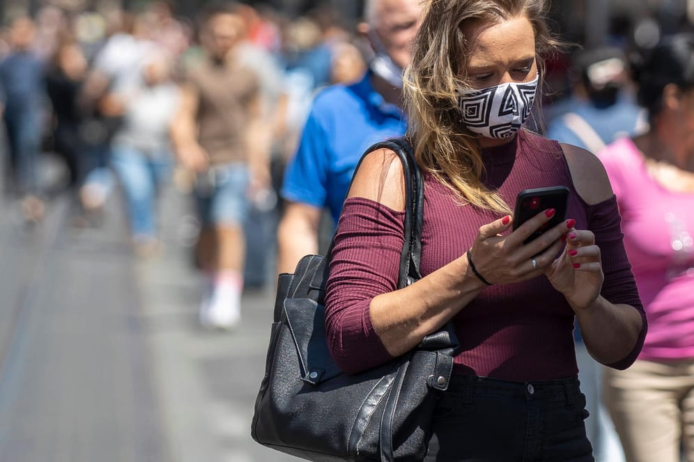 Eine Frau mit Smartphone: Die Corona-Warn-App soll bald erscheinen.