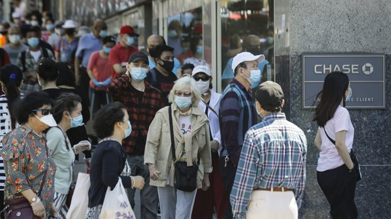 Menschen mit Masken in New York: Berechnungen zufolge hat die Maskenpflicht dort viele Menschen vor einer Ansteckung mit dem Coronavirus bewahrt.