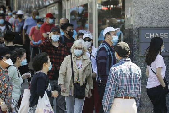 Menschen mit Masken in New York: Berechnungen zufolge hat die Maskenpflicht dort viele Menschen vor einer Ansteckung mit dem Coronavirus bewahrt.