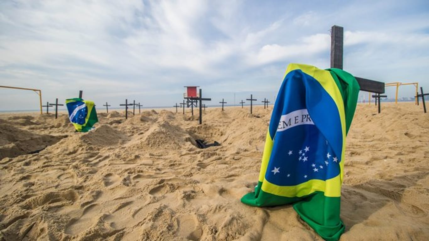 Protestaktion am berühmten Copacabana-Strand in Rio de Janeiro: Eine NGO hat Grabkreuze und brasilianische Flaggen aufgestellt.