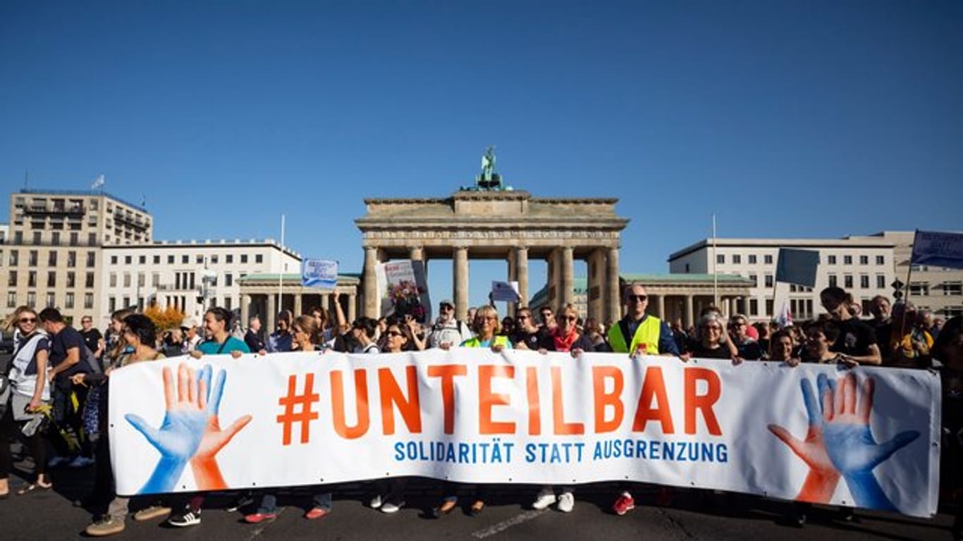 "Unteilbar" steht auf einem Plakat der Demonstrierenden