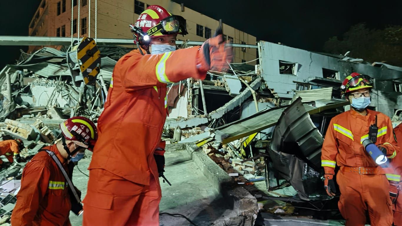 Feuerwehrleute arbeiten zwischen eingestürzten Gebäuden: Ein Tanklastwagen ist im Osten Chinas explodiert.