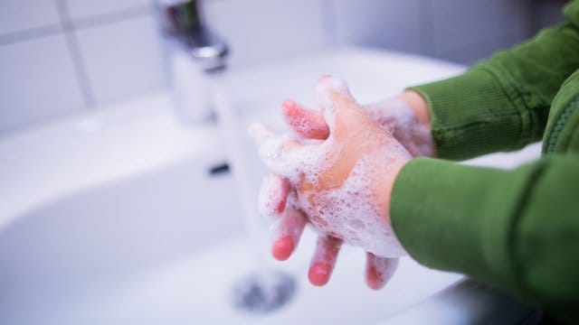 Ein Kind wäscht sich in einer Kindertagesstätte die Hände